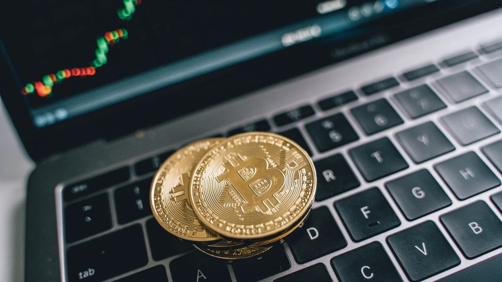 Bitcoin coins on a laptop representing the hardware used to participate in the network